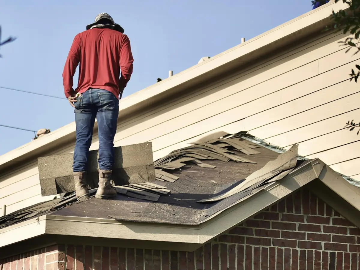 Roofer standing on a house roof during a roof replacement